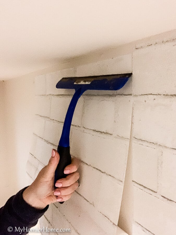 how to hang peel and stick wallpaper-11 Squeegee from the center out to smooth the peel and stick wallpaper.
