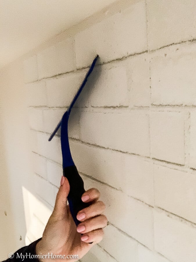 how to hang peel and stick wallpaper-12 Squeegee the peel and stick wallpaper from the center out, smoothing it and pulling the backing off as you go down.