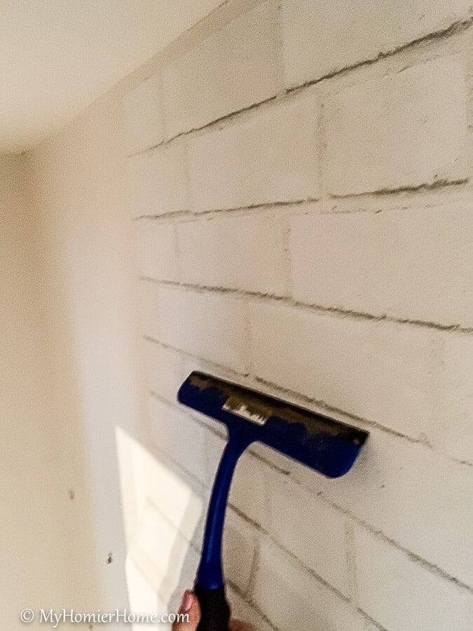 how to hang peel and stick wallpaper-14 Continue the process of removing the backing and smoothing from the center out until you reach the bottom of the wall with your peel and stick wallpaper.