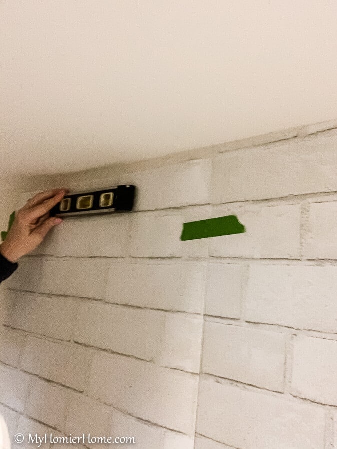 how to hang peel and stick wallpaper-4 Adjust the peel and stick wallpaper using a level to make sure the design is straight.
